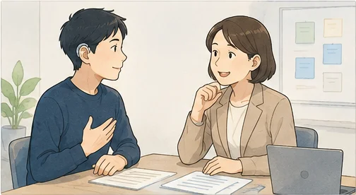 補聴器をつけた男性がチームリーダーと机をはさんで話し、胸に手を当てて自分の得意なこと・不得意なことを伝えている